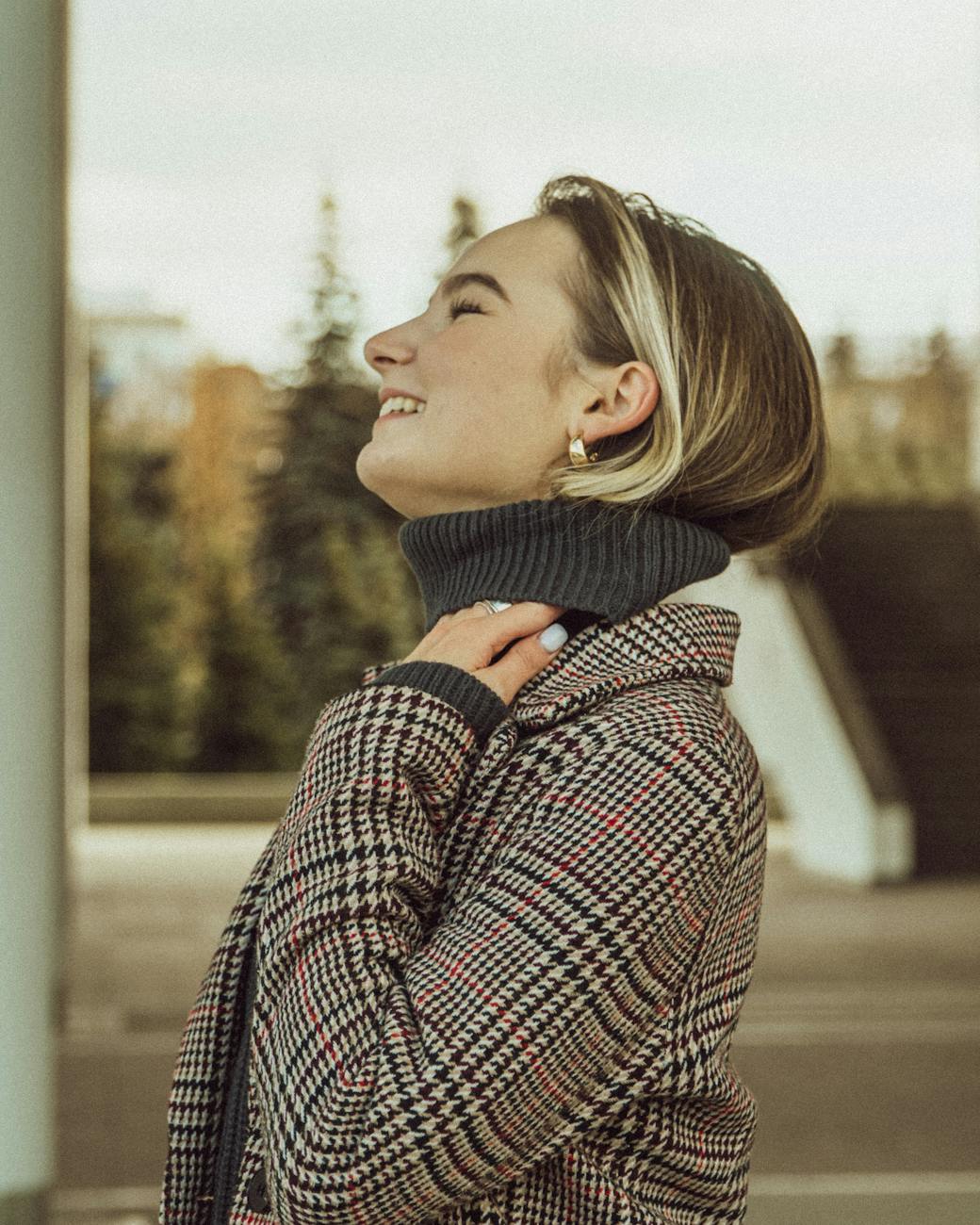 a woman in plaid blazer smiling