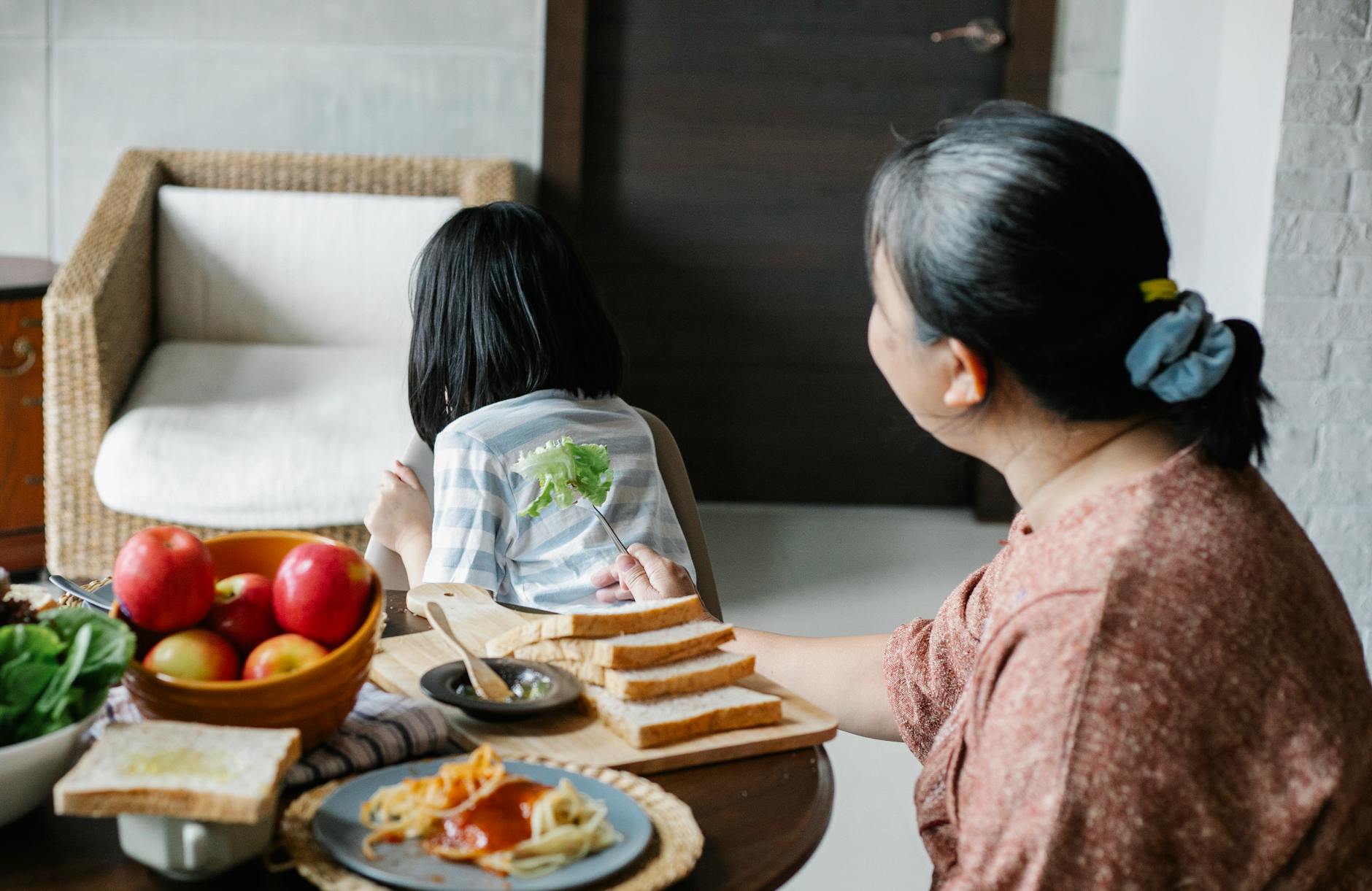 faceless woman with granddaughter having lunch